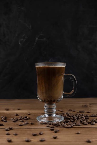 istock Steaming coffee over wooden surface and black background 1293406186