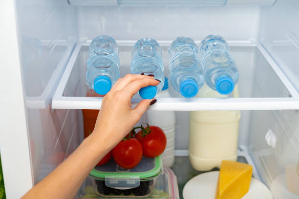 istock Female hand taking bottle of water from a fridge 1293407091