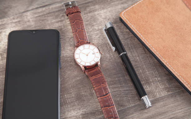 istock Wristwatch, smartphone, pen, notepad on the wooden background. 1293410348
