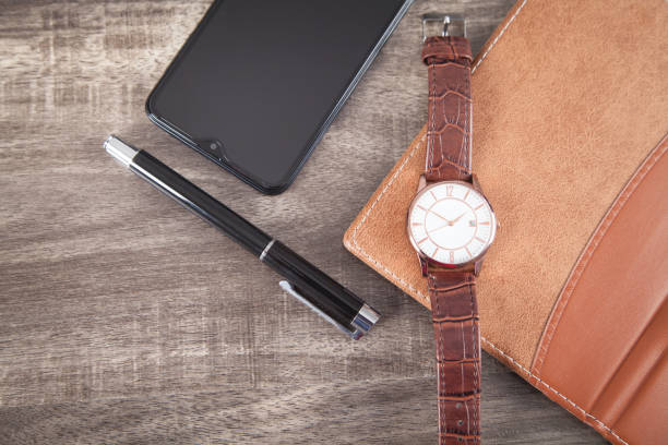istock Wristwatch, smartphone, pen, notepad on the wooden background. 1293410350