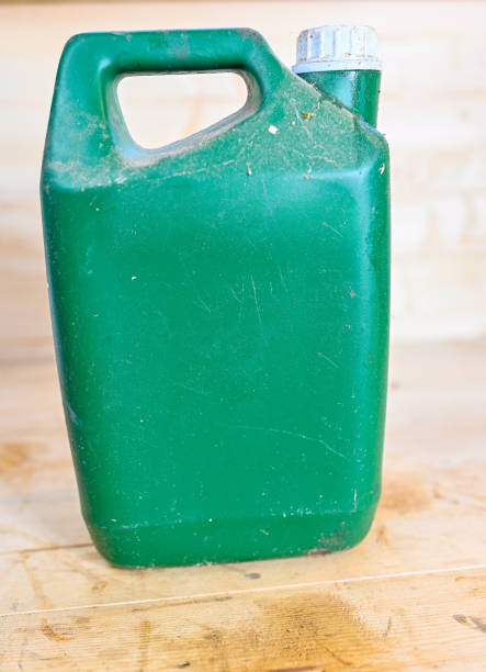 dirty old plastic gas can on wooden bench with white screw cap