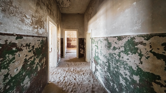 Kolmanskop Historic Diamond Mining Ghost Town Building Corridor Interior Panorama. Nature is coming back. Desert Sand entering the old abandoned german colonial building in the old deserted Diamond Mine Ghost Town at Kolmanskop, Lüderitz, Namibia, Africa.
