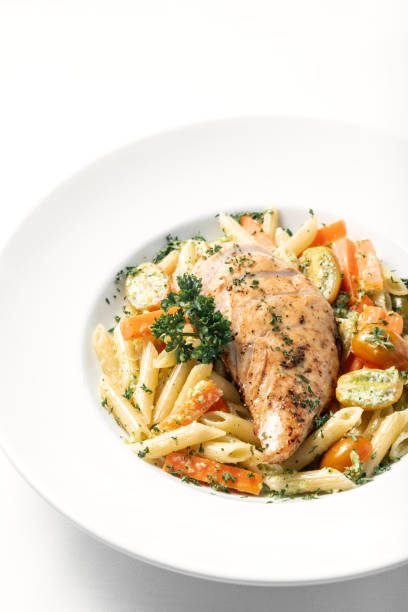 istock fried chicken breast with penne and saute vegetables pasta dish on white background 1293411444