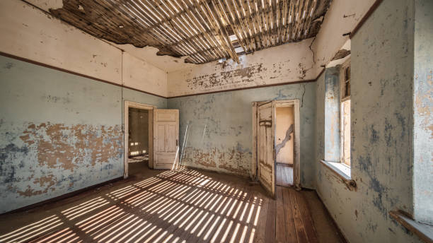 Namibia Ghost Town Light and Shadow Abandoned Building Kolmanskop Panorama Lüderitz Ghost Town Building Interior Panorama. Old rotting domestic room inside Ghost Town Building with Sunlight and Shadow Textures reflecting from the open roof. Old Building of abandoned Kolmanskop Diamond Mine, Lüderitz, Namibia, Africa kolmanskop namibia stock pictures, royalty-free photos & images