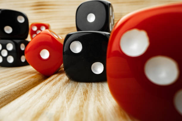 istock Red and black dice cubes on wooden background 1293415358