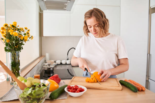 istock Woman chopping orange pepper with a knife 1293418002