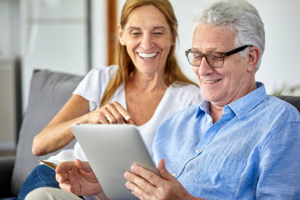 istock Happy seniors couple using digital tablet at home 1293418053