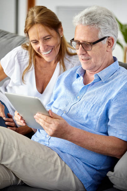 istock Happy seniors couple using digital tablet at home 1293418076