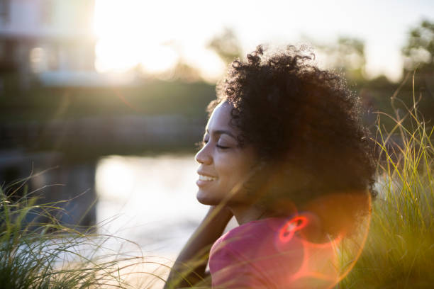 istock Young woman sitting by lakeshore 1293418341