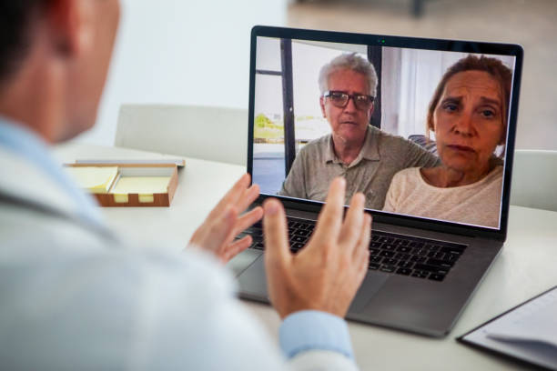 istock Doctor having video call with mature couple 1293418537
