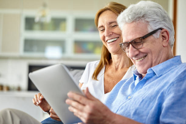 istock Happy seniors couple using digital tablet at home 1293422066