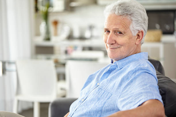 istock Smiling senior man sitting at home 1293422114