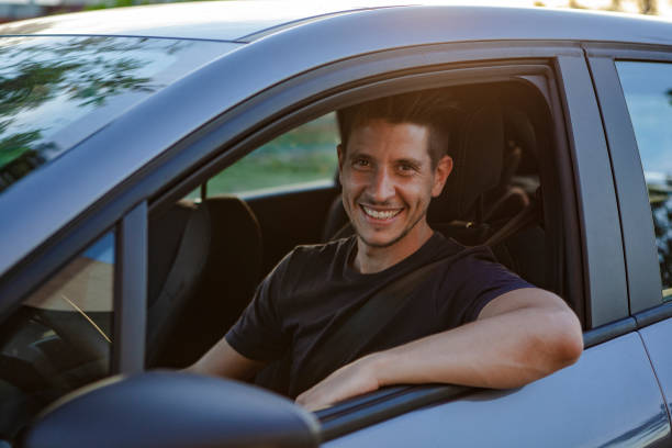 Man driving car Portrait of smiling man driving car on street seat belt photos stock pictures, royalty-free photos & images