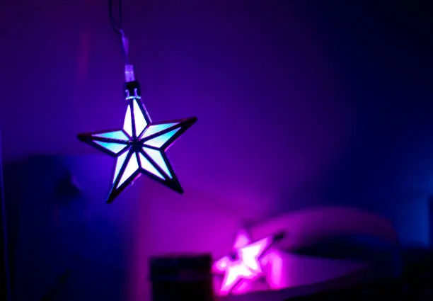 burning asterisk on a purple-lilac background in the dark, holiday, horizontal format