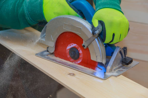 istock Carpenter using hand circular saw for cutting wooden boards with power tools. 1293425949