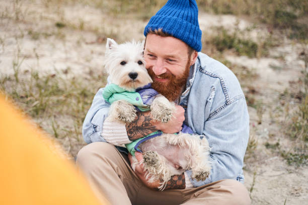 istock Man lovingly presses his white puppy 1293427461