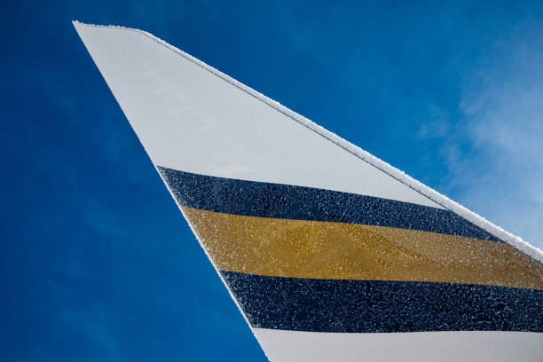 Frankfurt, Germany - May 04, 2016: The 63 feet high tail wing of a Lufthansa Boeing 747 Jumbo airliner, parking at a gate at Frankfurt international airport, is raging high into blue summer sky. the lower part of the rudder is still in position of slow final approach, only in cruise speed both parts are being moved simultaneously.