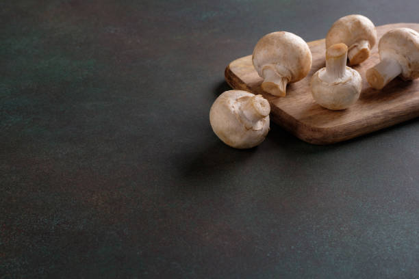 istock Champignon mushrooms lying on a cutting board with copy space 1293428581