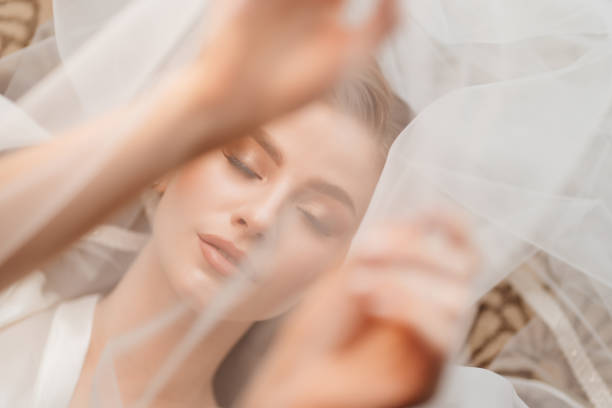 istock view top. a beautiful young woman is lying under a veil. hands over face. 1293429512