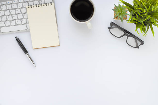 istock White office desk table with keyboard, notebook and coffee cup with equipment other office supplies. Business and finance concept. Workplace, Flat lay with blank copy space. Top view 1293430502