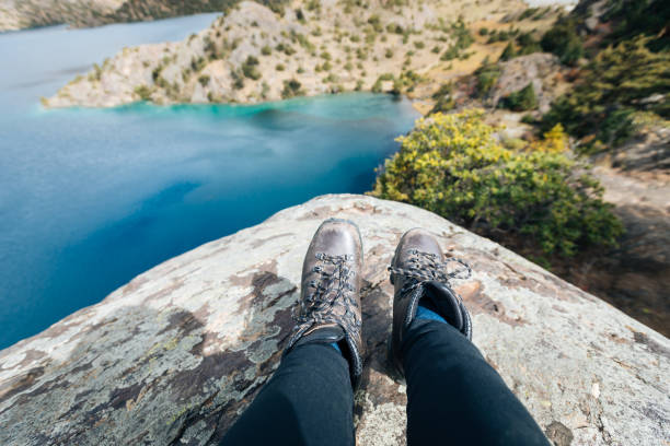 istock Hiker sit on cliff edge facing the beautiful high altitude lake 1293431777