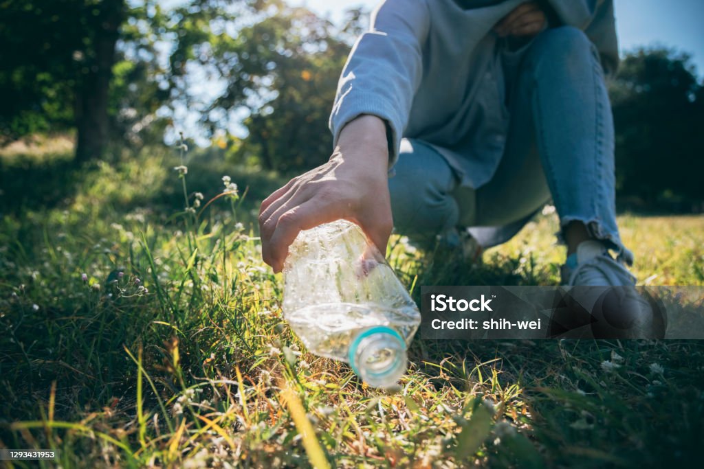 Woman hand holding garbage bottle plastic putting into recycle bag for cleaning Garbage Stock Photo