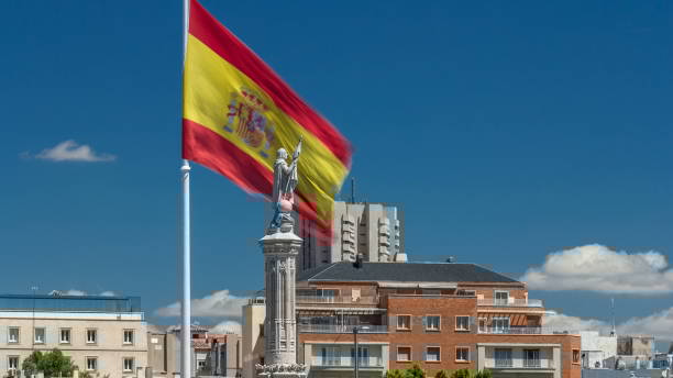 Spanish flag waves behind statue of Christopher Columbus timelapse, plaza de Colon in Madrid, Spain Spanish flag waves behind statue of Christopher Columbus timelapse with clouds on blue sky, plaza de Colon in Madrid, Spain the flag of the madrid spain stock pictures, royalty-free photos & images