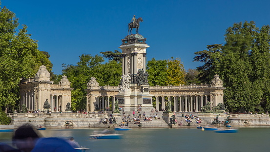 Tourists on boats at Monument to Alfonso XII timelapse in the Parque del Buen Retiro - Park of the Pleasant Retreat in Madrid, Spain