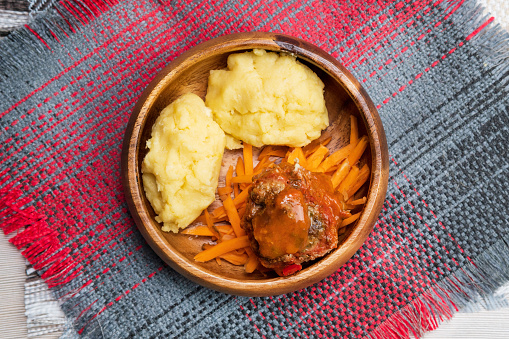 Grouper moqueca served with saffron rice, farofa and pirão and pepper sauce. Typical Brazilian food.