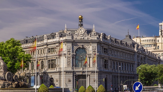 Historic Bank of Spain building timelapse with monument The Cybele Fountain and Cibeles square between Paseo del Prado and Alcala street with car traffic in Madrid, Spain