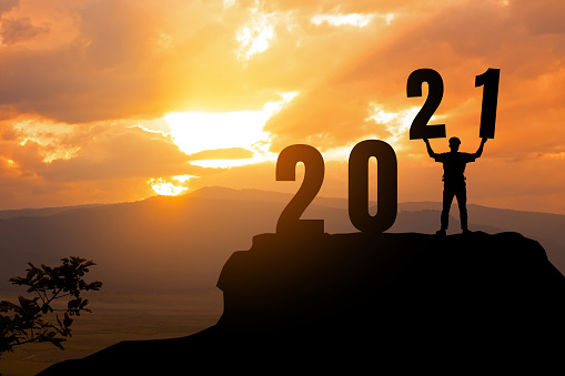 Silhouette freedom man holding number 2,1 on peaks with New year 2021.2021 New year Success concept.