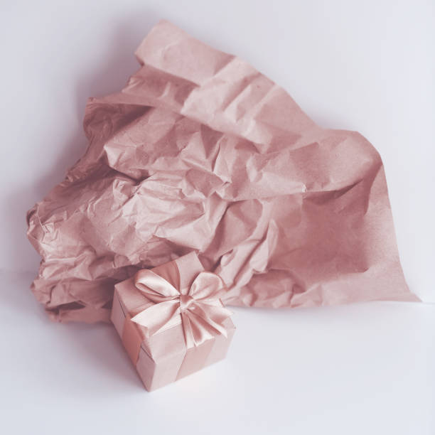 istock Toned pink coloured image, brown paper gift box with satin ribbon 1293437673