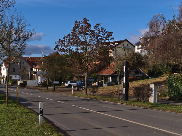 czarny fotoradar do kontroli ruchu przy wjeździe do wioski wschodniej z budynkami drogowymi i mieszkalnymi w słoneczny dzień w sezonie zimowym. - hagnau zdjęcia i obrazy z banku zdjęć