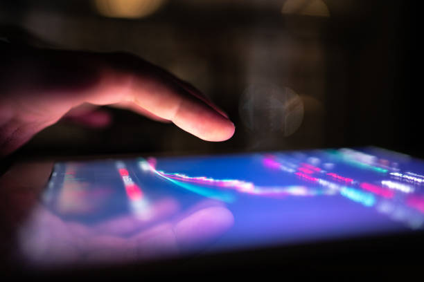 Male hand using digital tablet / smartphone at night