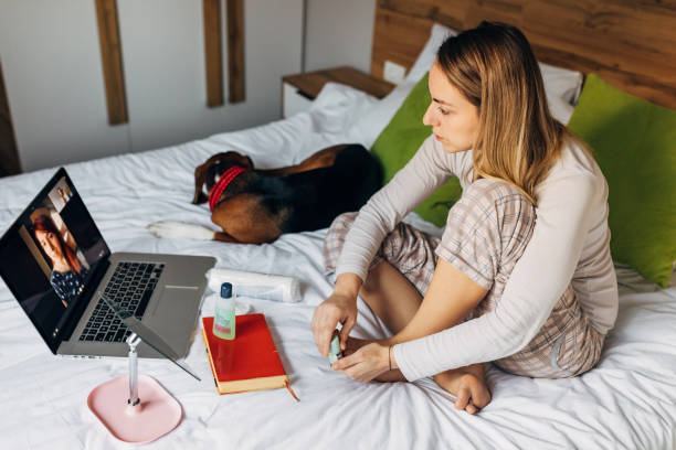 istock During their virtual spa day, cheerful woman doing her pedicure while her hound dog makes her a company 1293441773
