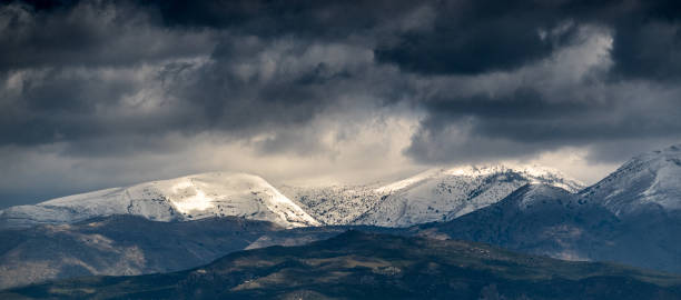 Photo of Clouds over the snow-capped mountain
