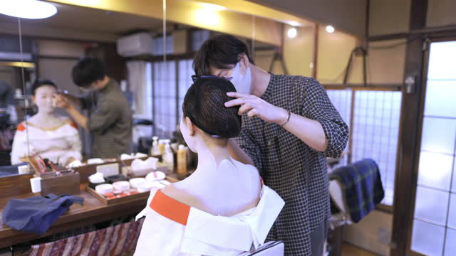 Staff applying special 'Maiko' (Geisha in training) makeup to customer - part 1 of 2