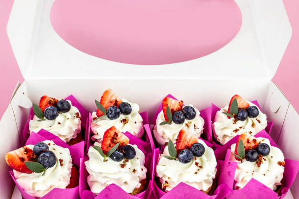 istock Delicious cupcakes with cream and fresh berries in box. 1293443552