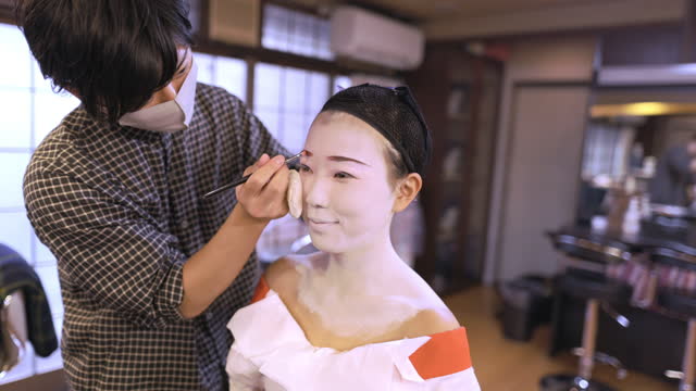 Staff applying special 'Maiko' (Geisha in training) makeup to customer - part 2 of 2