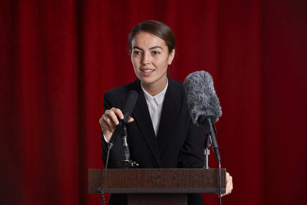 istock Young Woman Giving Speech on Stage 1293444870