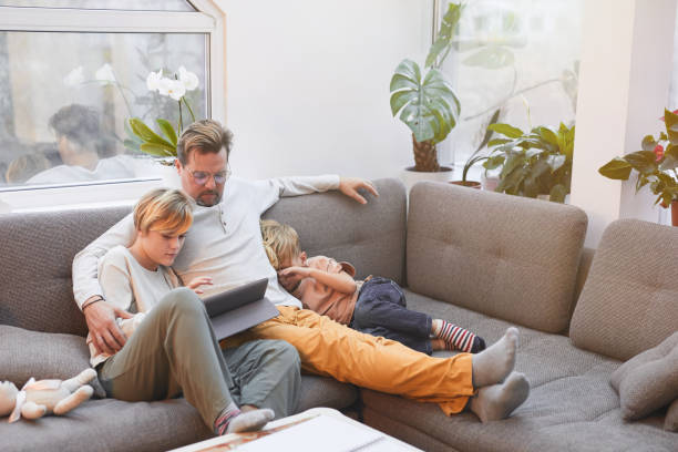 istock Father and Sons Sitting on Sofa Together 1293445983