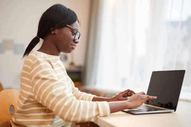 istock Young African-American Woman Using Laptop at Home 1293446897
