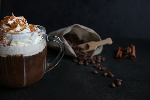 Cappuccino with cinnamon. A glass of fresh cappuccino on the table