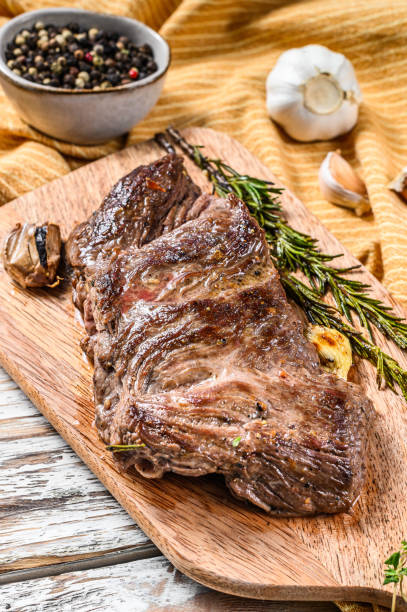 istock Grilled outside skirt steak on a chopping Board. White background. Top view 1293448163