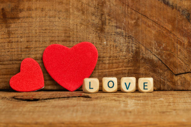 istock Two red paper hearts on a wooden background 1293448292