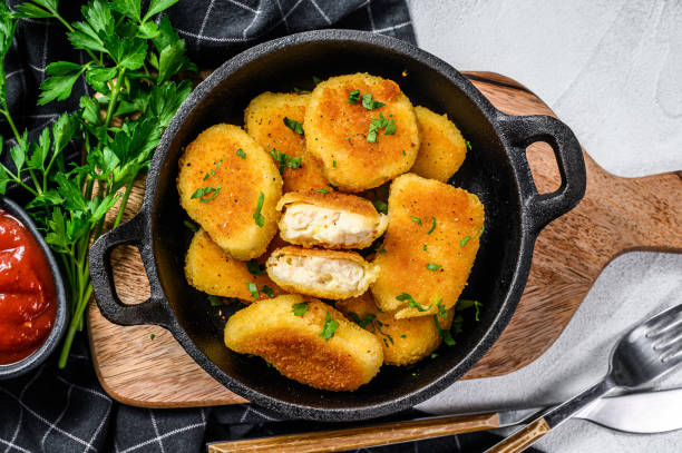 istock Crispy fried chicken nuggets in a pan with ketchup and herbs. White background. Top view 1293451892