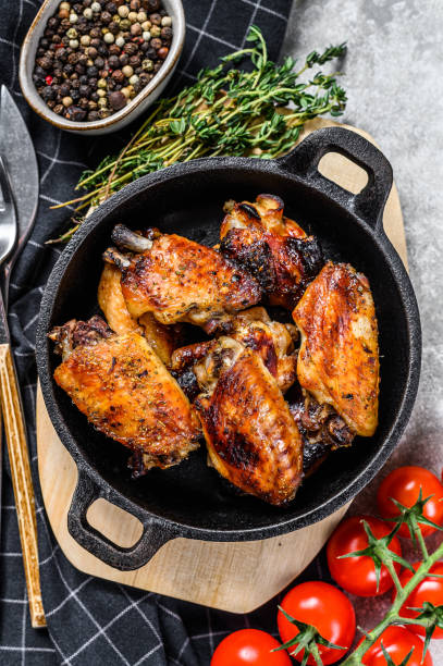 istock Baked glazed chicken wings in a pan. Gray background. Top view 1293452183