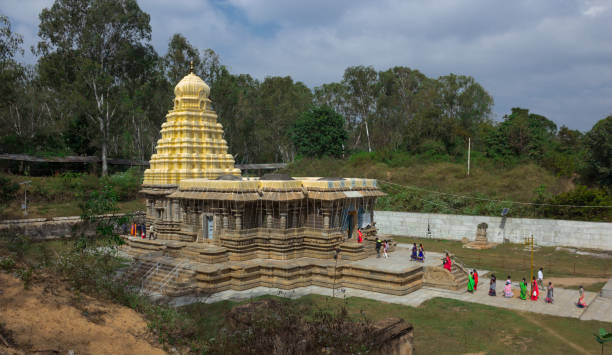 un antico tempio in pietra indù dedicato al signore shiva con i pellegrini nella città di talakadu vicino a mysuru in india. - indian ethnicity traditional culture architecture karnataka foto e immagini stock