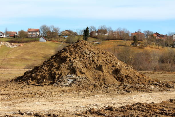 istock Large pile of dry soil mixed with rocks and construction material at local construction site in front of small hill 1293453016