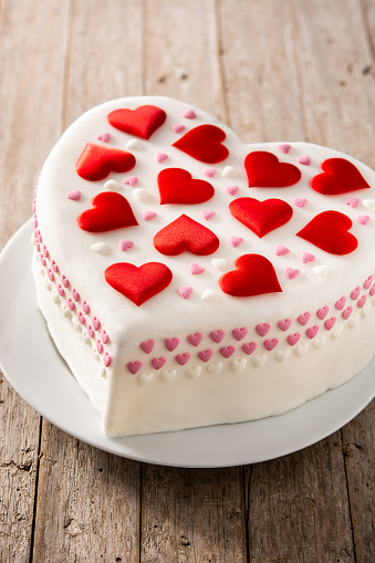 Heart cake for St. Valentine's Day, Mother's Day, or Birthday, decorated with roses and pink sugar hearts on red background
